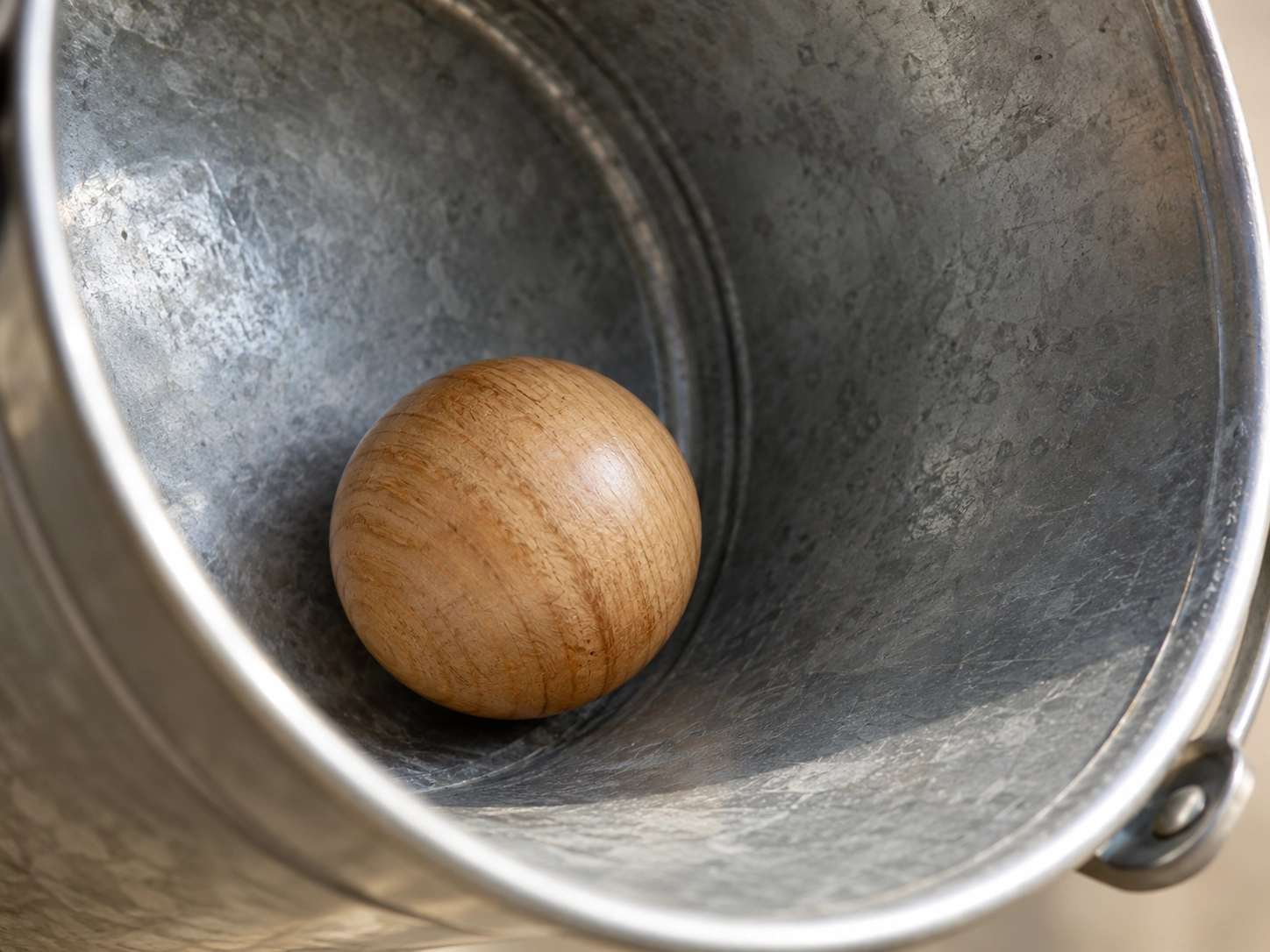 Wooden garden-game ball inside a traditional metal bucket